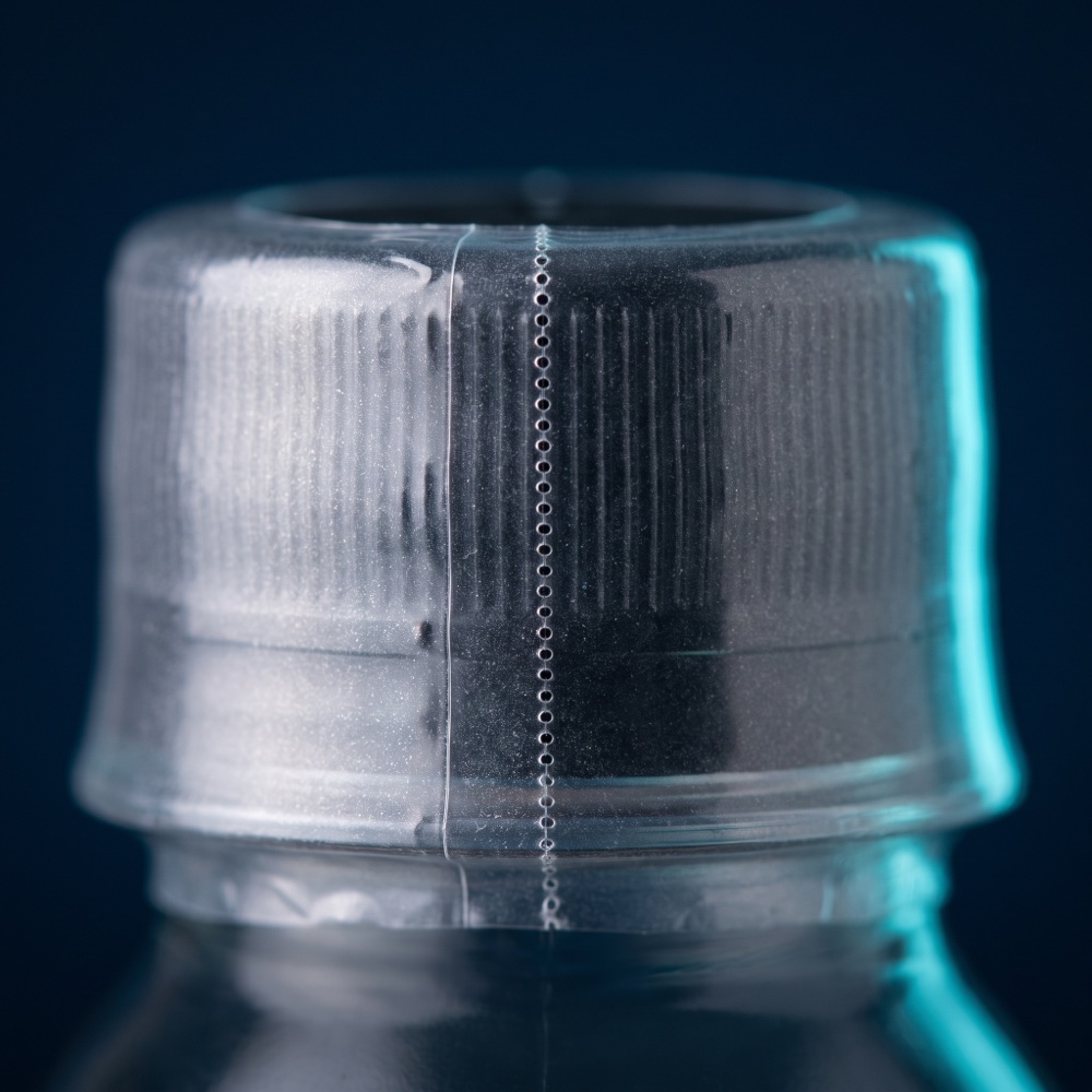 Clear shrink neck band sealing a bottle cap